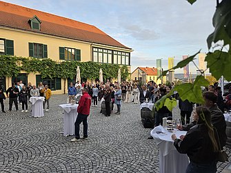 Das Bild zeigt eine Gruppe von Menschen im Innenhof der Winzer Krems beim Empfang zum WACHAUmarathon 2026