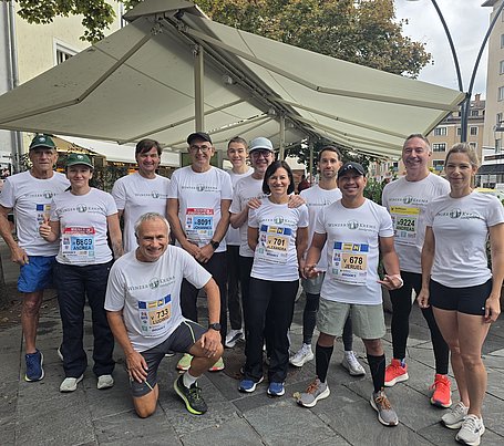 Das Laufteam der Winzer Krems beim Wachaumarathon 2026. Es ist ein Gruppenfot mit insgesamt 11 Personen, die alle ein weißes WINZER KREMS-Laufshirt tragen. 